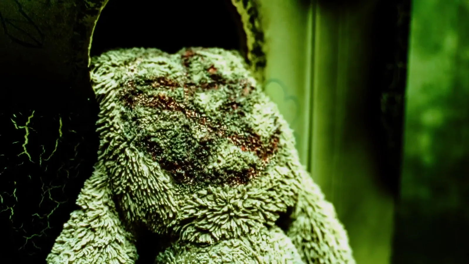 A torn, stained teddy bear in sickly green light in The Haunting at Escape This Northbridge